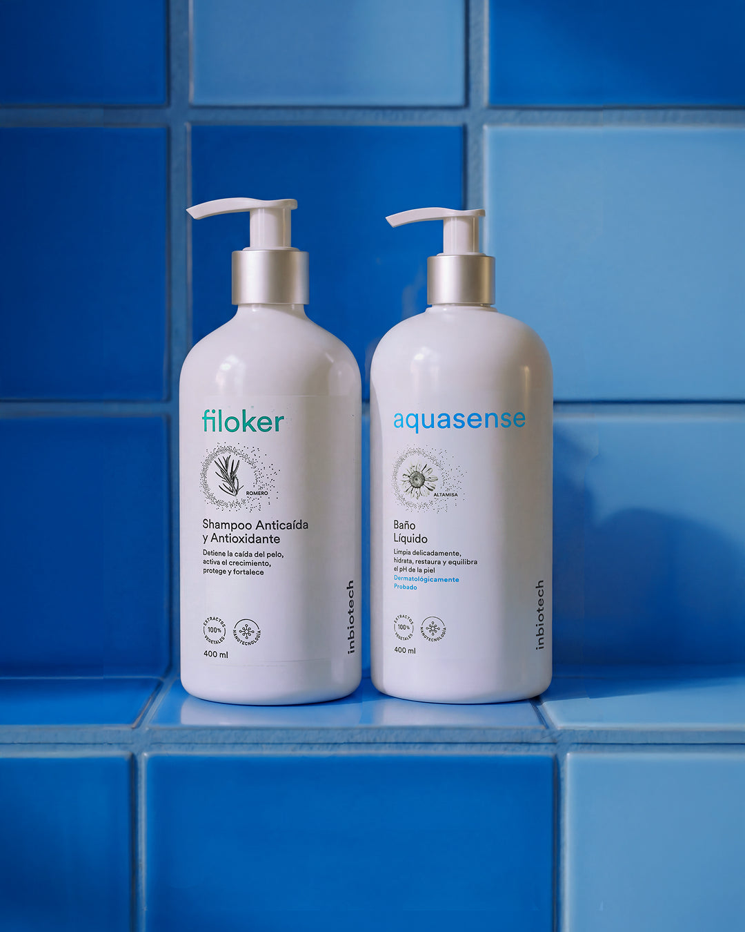 Botellas de shampoo Filoker y baño líquido Aquasense con dispensador tipo bomba exhibidas en un ambiente de baño con azulejos azules